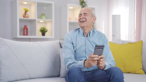 Old-man-laughing-at-phone-message.